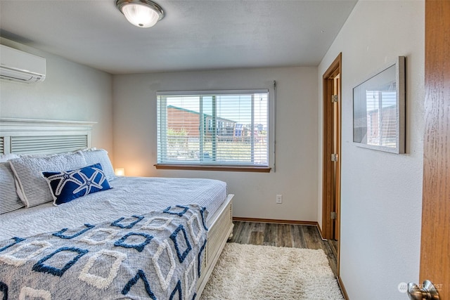 bedroom with dark hardwood / wood-style flooring and a wall mounted air conditioner