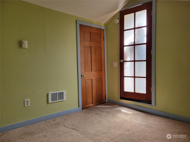 carpeted empty room featuring a healthy amount of sunlight and vaulted ceiling