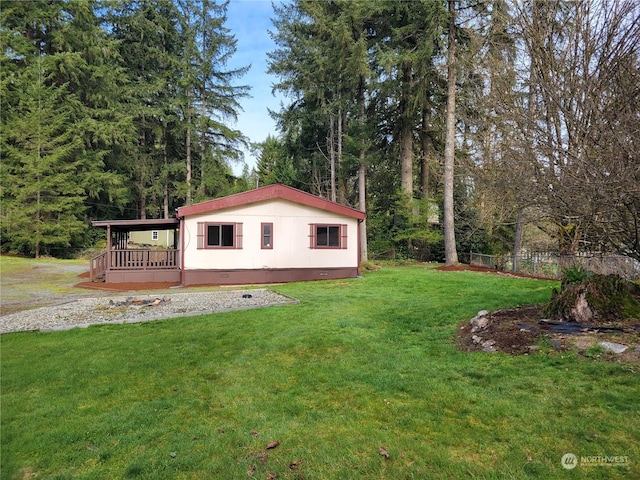 view of side of property featuring a wooden deck and a yard