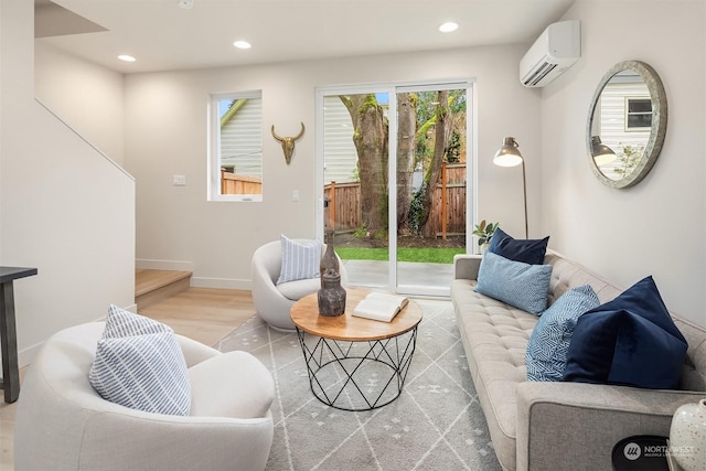 living room with a wall mounted air conditioner and light hardwood / wood-style flooring