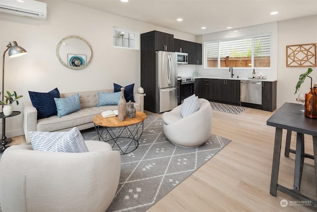 living room with light wood-type flooring, a wall mounted AC, and sink