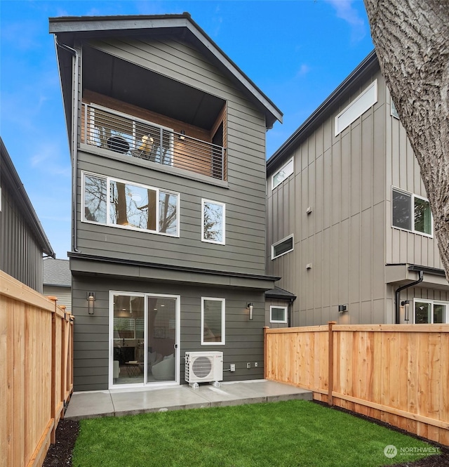 rear view of property featuring a lawn, a patio, and ac unit