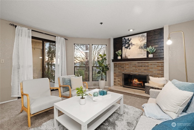 carpeted living room featuring a fireplace and a textured ceiling