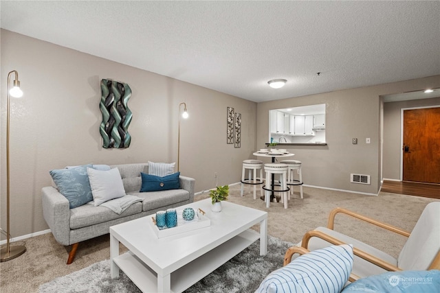 living room featuring light carpet and a textured ceiling