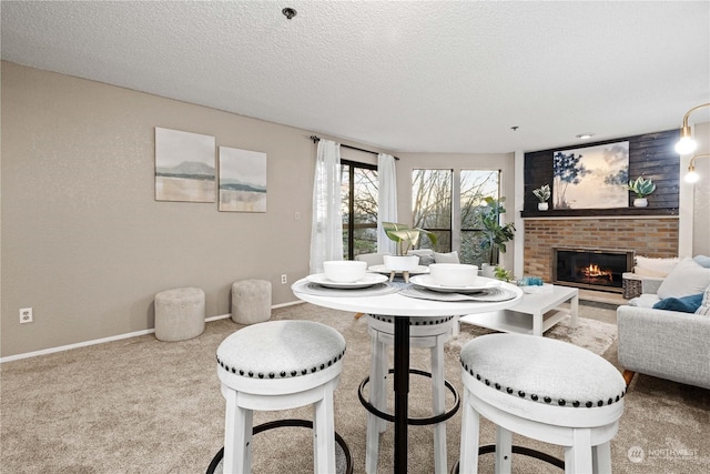 carpeted dining area featuring a fireplace and a textured ceiling