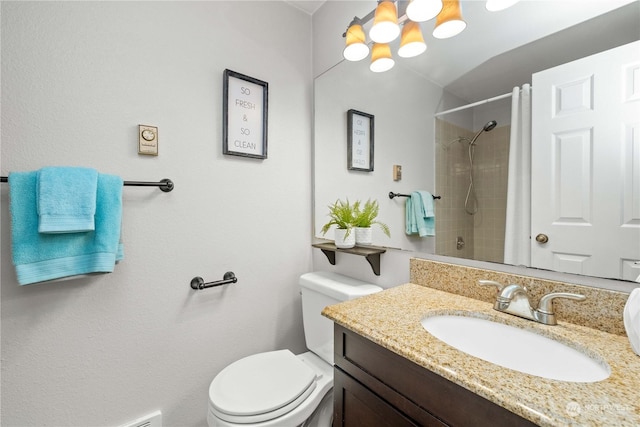 bathroom with vanity, toilet, and tiled shower