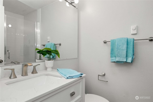 bathroom with vanity and a shower with door