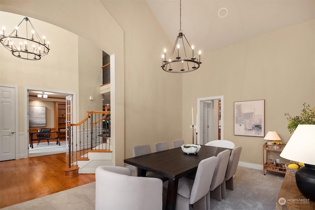 dining room with an inviting chandelier, hardwood / wood-style flooring, and high vaulted ceiling