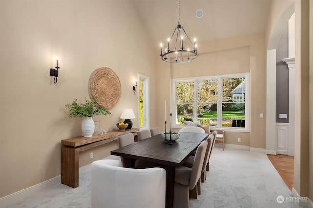 carpeted dining room featuring a high ceiling and a notable chandelier