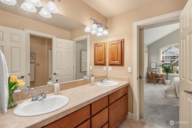 bathroom with vanity, an inviting chandelier, and tile patterned flooring