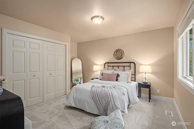 bedroom featuring light colored carpet and a closet