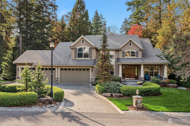 view of front of house with stone siding, driveway, an attached garage, and a front lawn