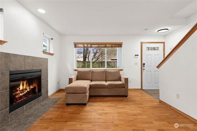 living room with hardwood / wood-style floors and a tile fireplace