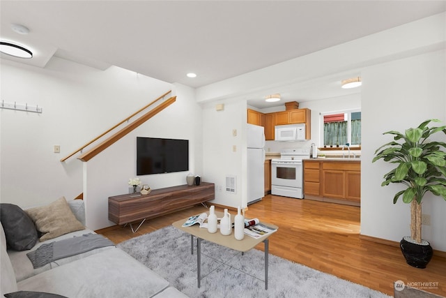 living room with sink and light hardwood / wood-style flooring