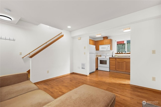 unfurnished living room featuring light hardwood / wood-style floors and sink