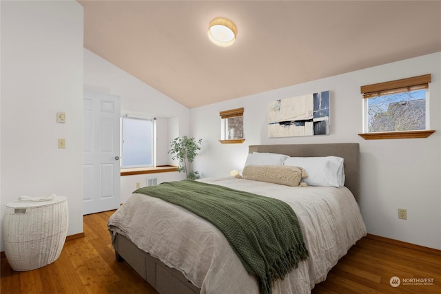 bedroom featuring wood-type flooring and vaulted ceiling