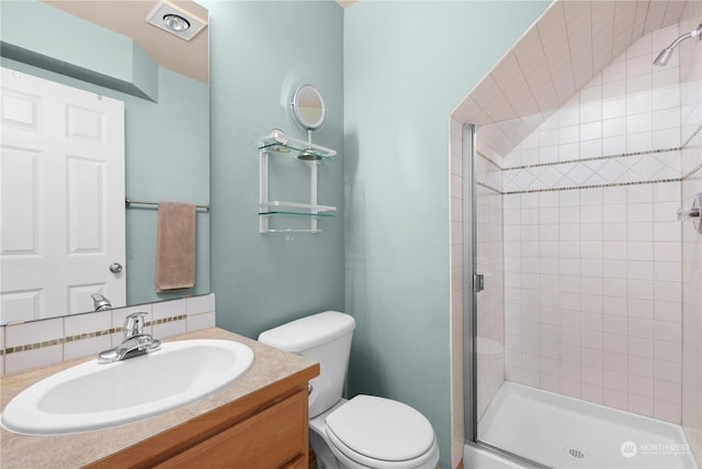 bathroom featuring vanity, toilet, a shower with door, and decorative backsplash