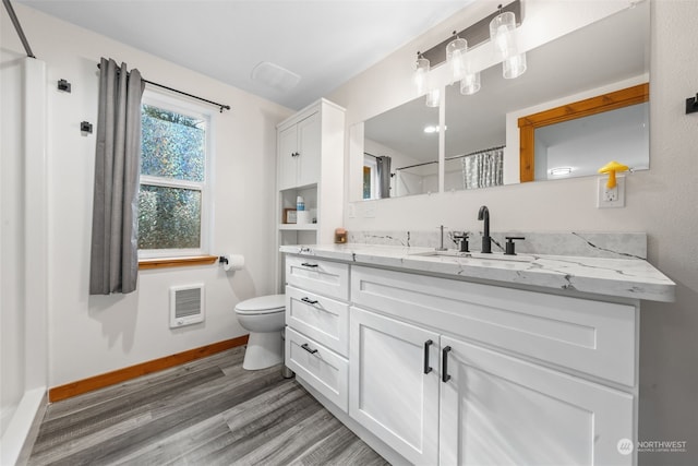 bathroom featuring vanity, hardwood / wood-style flooring, a shower with curtain, and toilet