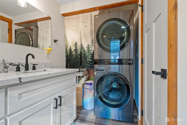 laundry room with dark wood-type flooring, stacked washer / drying machine, and sink