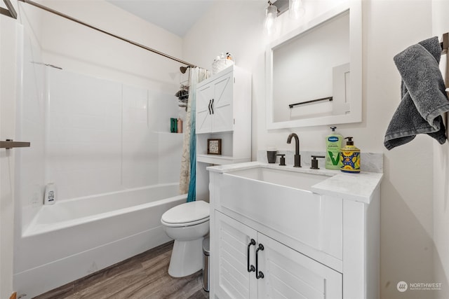 full bathroom featuring hardwood / wood-style flooring, vanity, shower / bath combination with curtain, and toilet