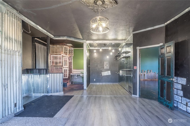 interior space with crown molding, an inviting chandelier, and hardwood / wood-style floors