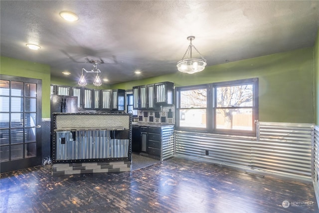 kitchen featuring black refrigerator, hanging light fixtures, and a textured ceiling