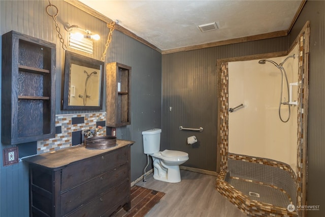 bathroom featuring vanity, crown molding, wood-type flooring, and a shower