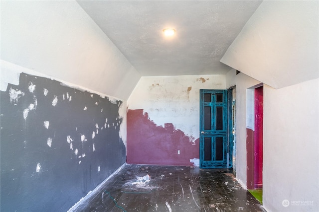 additional living space featuring vaulted ceiling and a textured ceiling