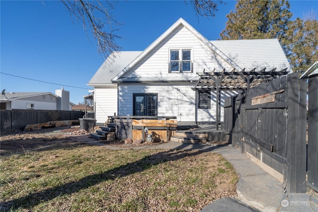 back of property with a lawn and a pergola