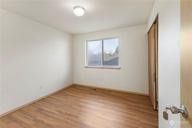 unfurnished bedroom featuring light hardwood / wood-style floors and a closet