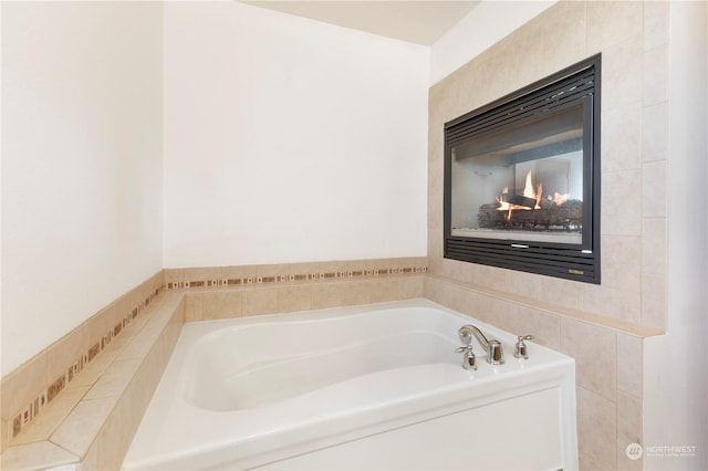 bathroom featuring a multi sided fireplace and a bathing tub