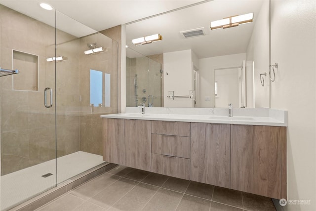 bathroom with tile patterned floors, a shower with door, and vanity