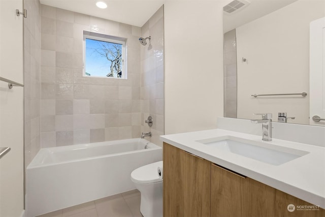 full bathroom featuring tile patterned floors, toilet, tiled shower / bath combo, and vanity