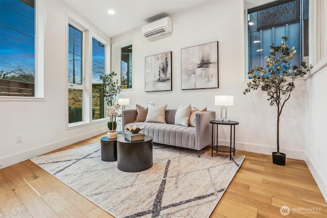 sitting room with recessed lighting, light wood-style flooring, baseboards, and a wall mounted AC