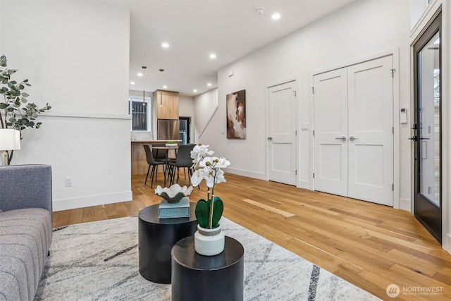 living area featuring light wood-style flooring, baseboards, and recessed lighting