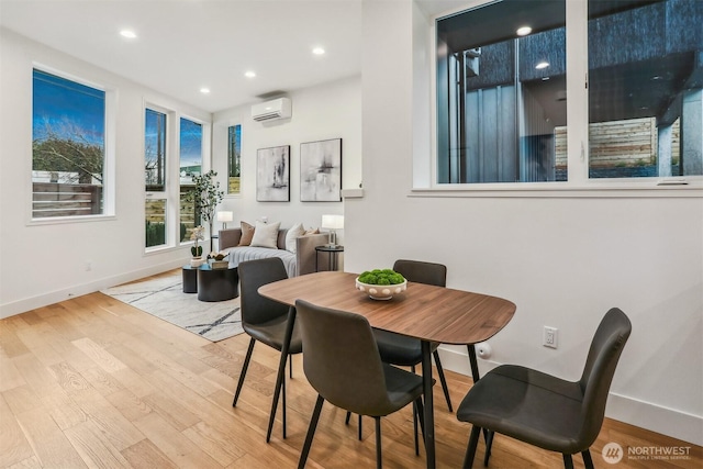 dining area with a wall unit AC, light wood finished floors, baseboards, and recessed lighting