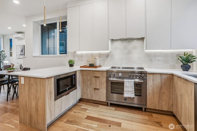 kitchen featuring light countertops, appliances with stainless steel finishes, modern cabinets, and white cabinets