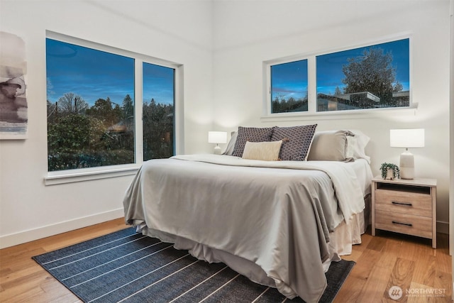 bedroom featuring baseboards and wood finished floors