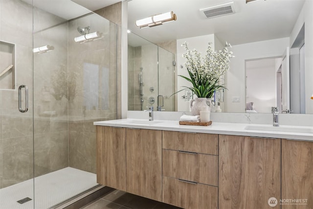 ensuite bathroom with tile patterned floors, visible vents, a sink, and double vanity