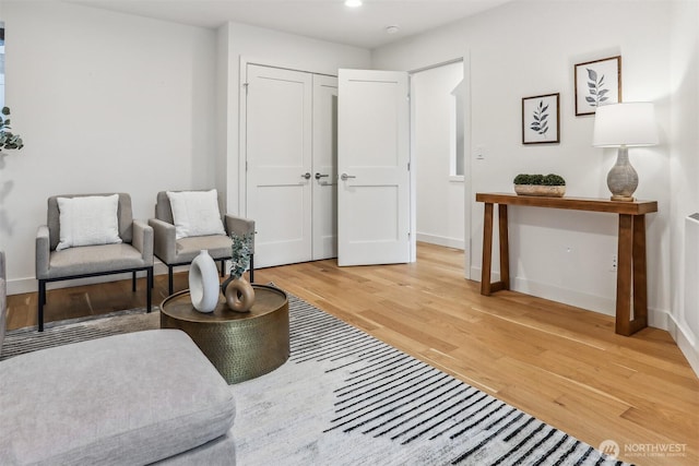 living area with recessed lighting, baseboards, and wood finished floors