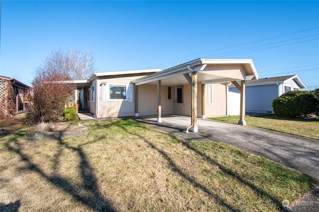 back of house featuring a carport and a lawn