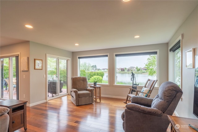 living room with a water view and light hardwood / wood-style floors