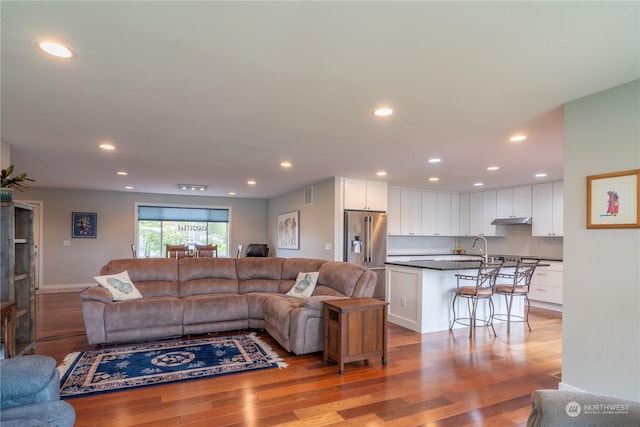 living room featuring sink and light hardwood / wood-style flooring