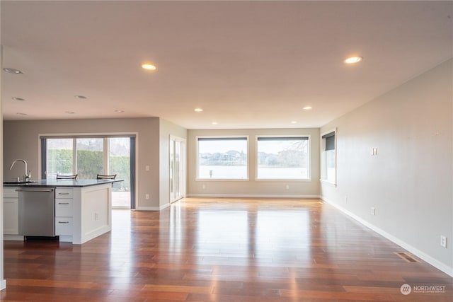 unfurnished living room with dark hardwood / wood-style flooring and sink