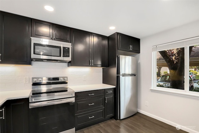 kitchen with decorative backsplash, appliances with stainless steel finishes, and dark wood-type flooring