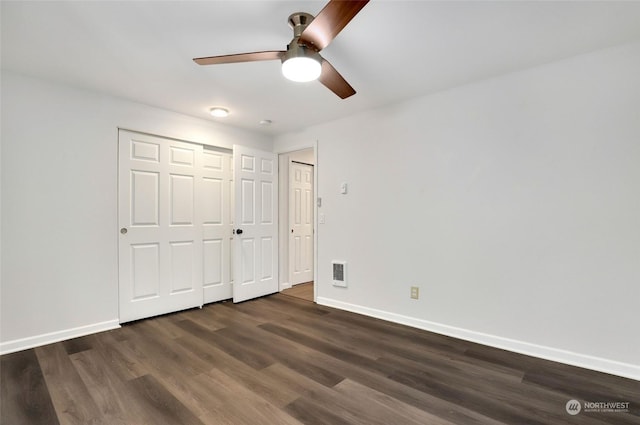 unfurnished bedroom featuring a closet, dark hardwood / wood-style floors, and ceiling fan