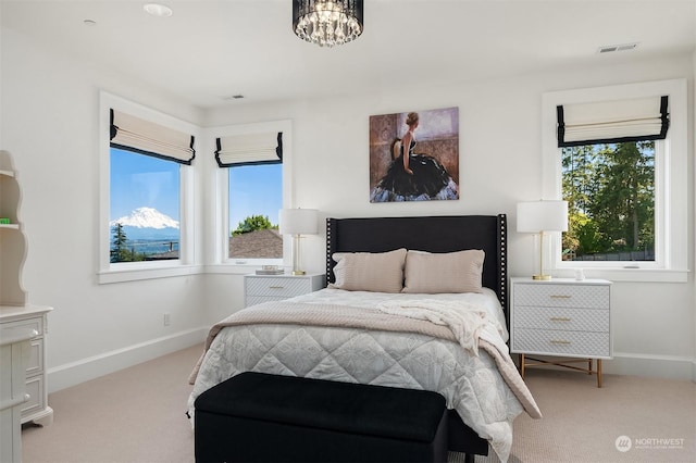 bedroom featuring light carpet and a notable chandelier