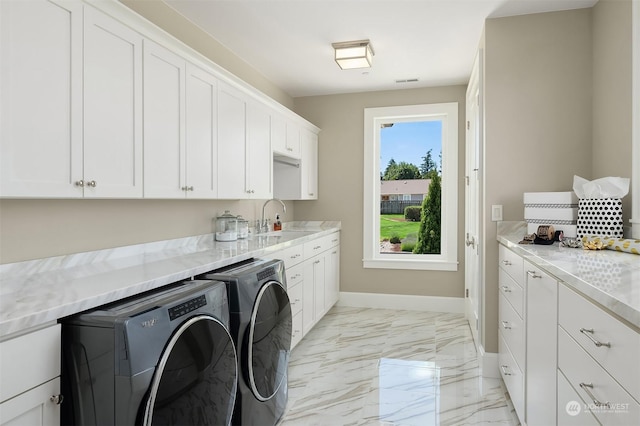 clothes washing area featuring sink, cabinets, and washing machine and dryer