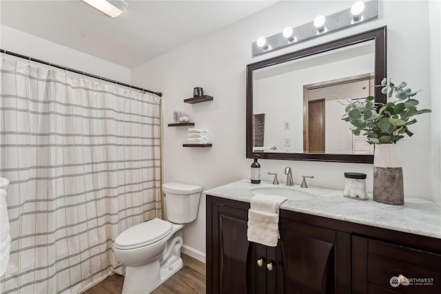 bathroom featuring vanity, hardwood / wood-style flooring, and toilet