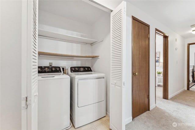 clothes washing area with washing machine and clothes dryer and light carpet